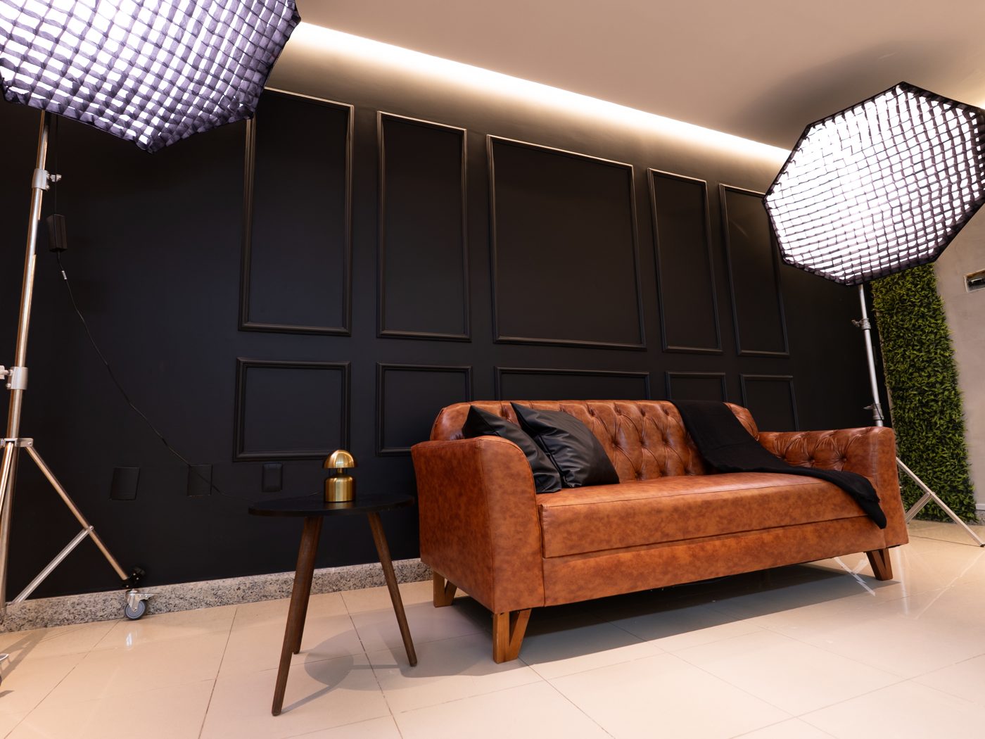 Parede preta com boiserie e sofá Chesterfield de couro